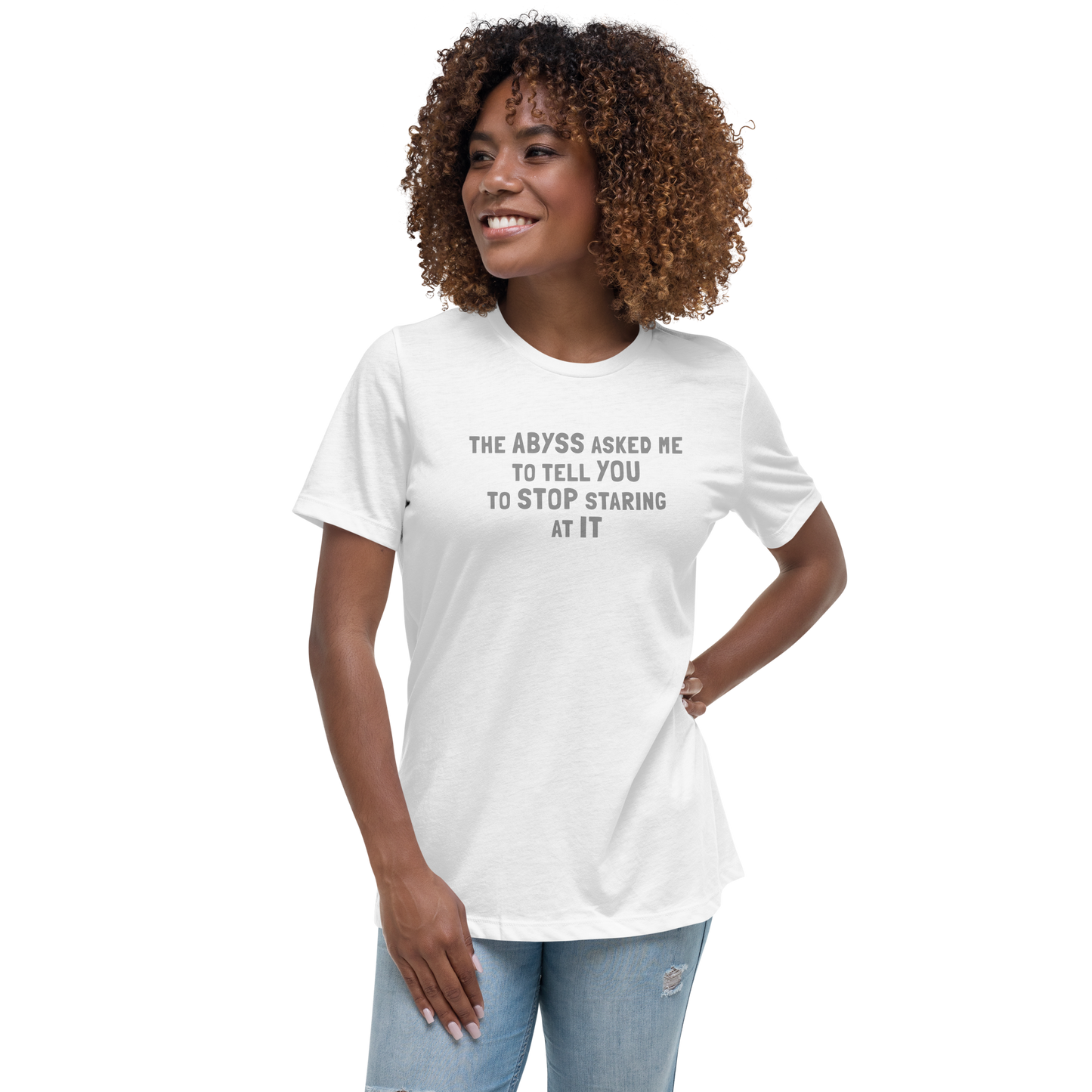 "The Abyss asked me to tell you to stop staring at it" printed on a white women's relaxed t-shirt worn by a female