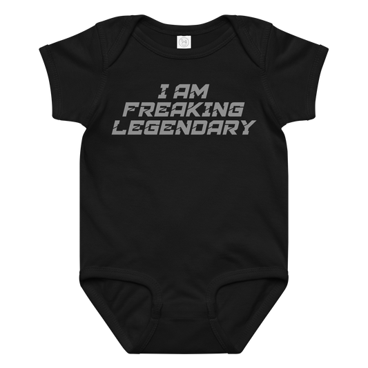 "I Am Freaking Legendary" printed on a black baby jersey bodysuit laying on a flat surface amongst other clothes