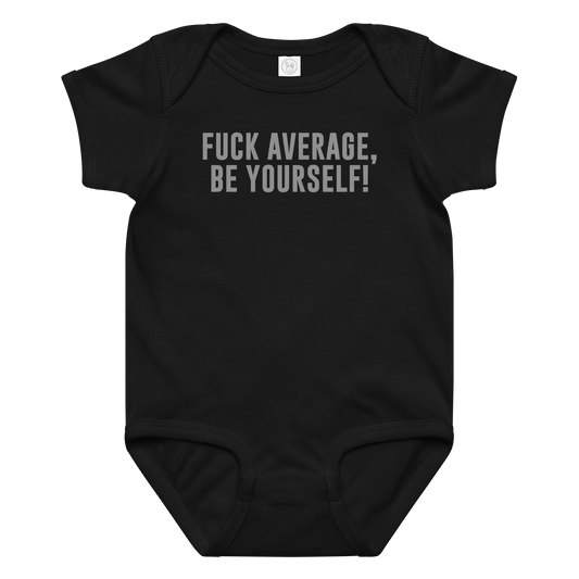 "Fuck Average, Be Yourself!" printed on a black baby jersey bodysuit laying on a flat surface amongst other clothes