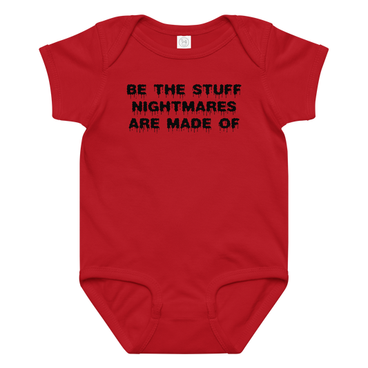 "Be the stuff nightmares are made of" printed on a red baby jersey bodysuit laying on a flat surface amongst other clothes