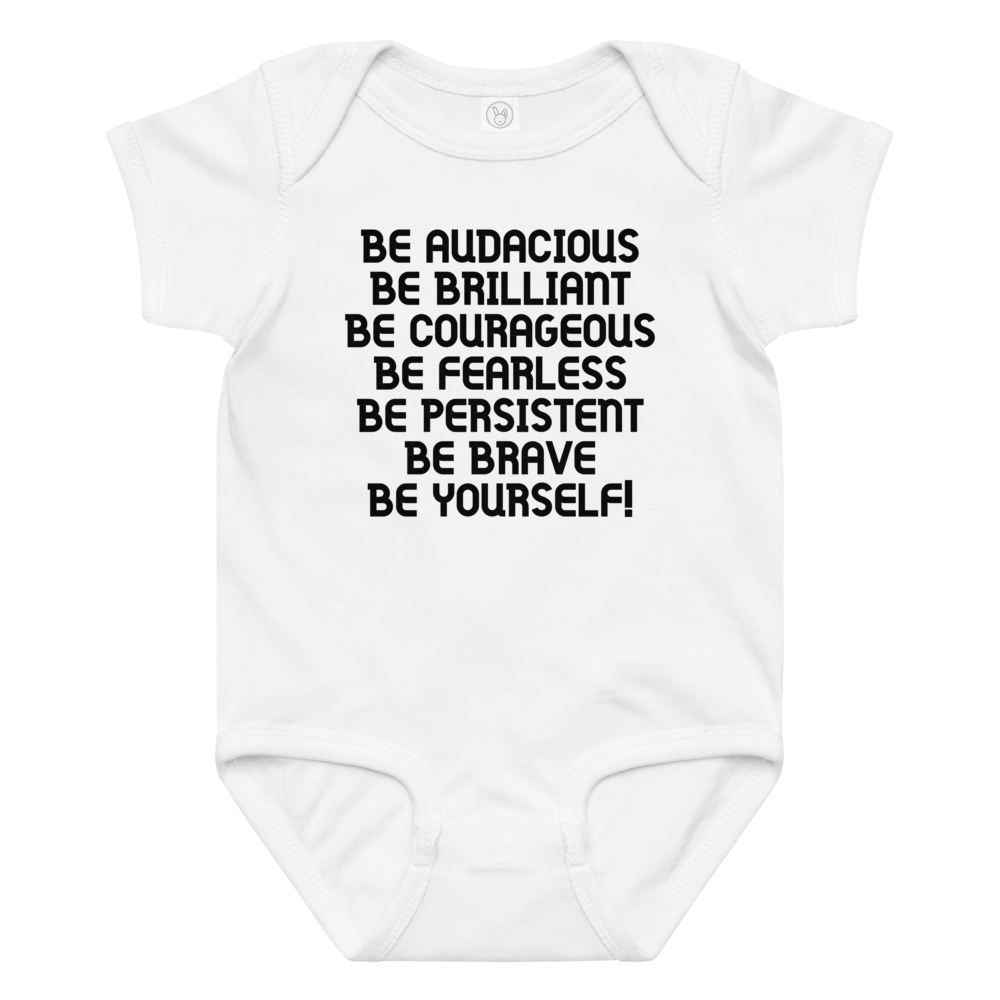 "Be Audacious Be Brilliant Be Courageous Be Fearless Be Persistent Be Brave Be Yourself!" printed on a white baby jersey bodysuit laying on a flat surface amongst other clothes