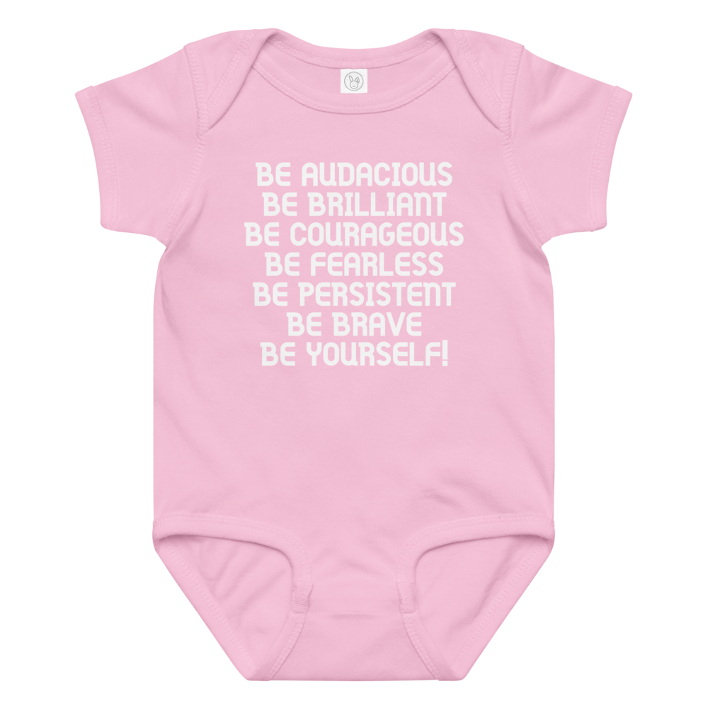 "Be Audacious Be Brilliant Be Courageous Be Fearless Be Persistent Be Brave Be Yourself!" printed on a pink baby jersey bodysuit laying on a flat surface amongst other clothes