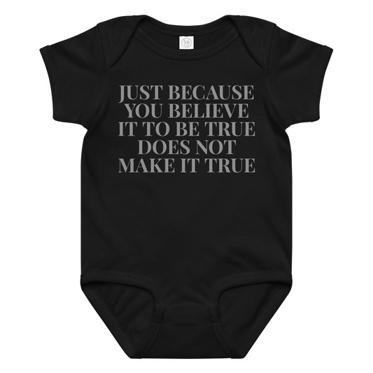 "Just because you believe it to be true does not make it true" printed on a black baby jersey bodysuit laying on a flat surface amongst other clothes