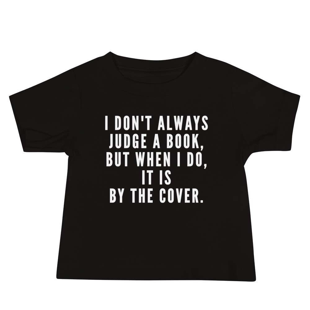"I Don't always Judge a Book, but when I do, it's by the cover." printed on a black baby jersey short sleeve tee laying on a flat surface