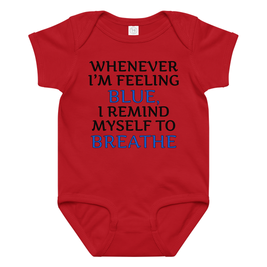 "Whenever I'm feeling blue, I remind myself to breathe" printed on a red baby jersey bodysuit laying on a flat surface amongst other clothes