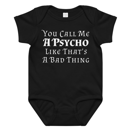 "You Call Me A Psycho Like That's A Bad Thing" printed on a black baby jersey bodysuit laying on a flat surface amongst other clothes