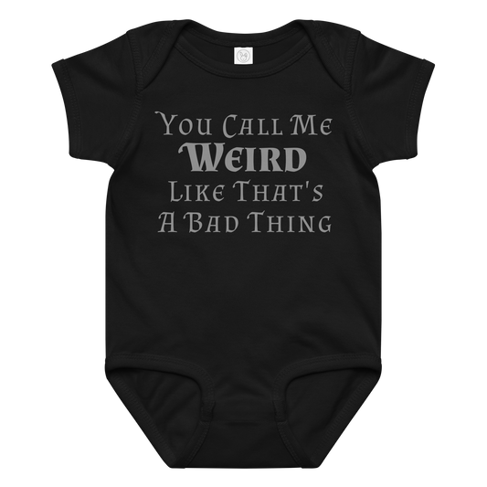"You Call Me Weird Like That's A Bad Thing" printed on a black baby jersey bodysuit laying on a flat surface amongst other clothes