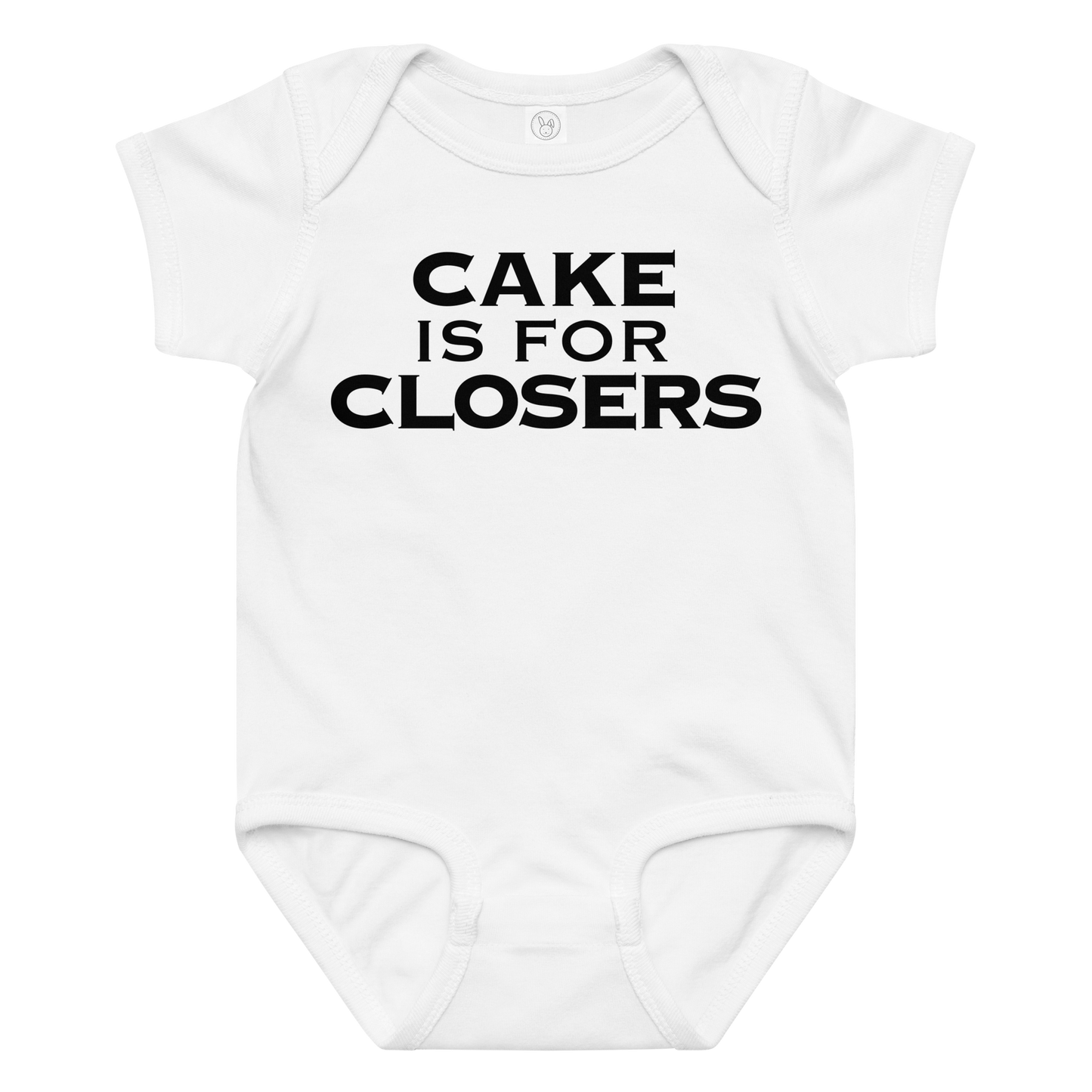 "Cake Is For Closers" printed on a white baby jersey bodysuit laying on a flat surface amongst other clothes