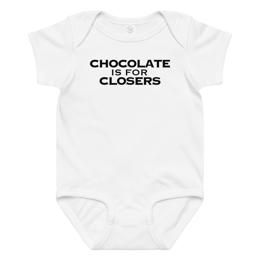 "Chocolate Is For Closers" printed on a white baby jersey bodysuit laying on a flat surface amongst other clothes