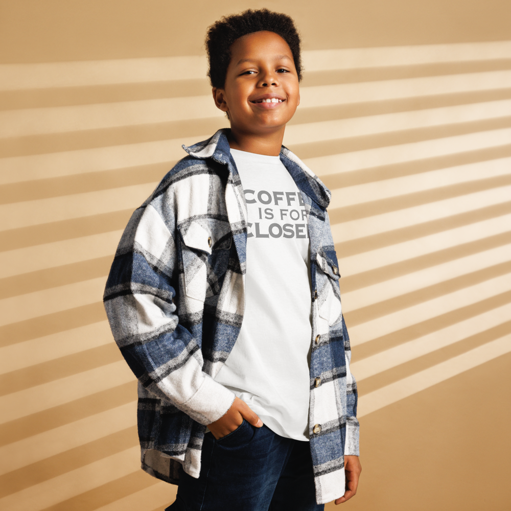 "Coffee Is For Closers" printed on a white youth classic tee worn by a male also wearing a jacket