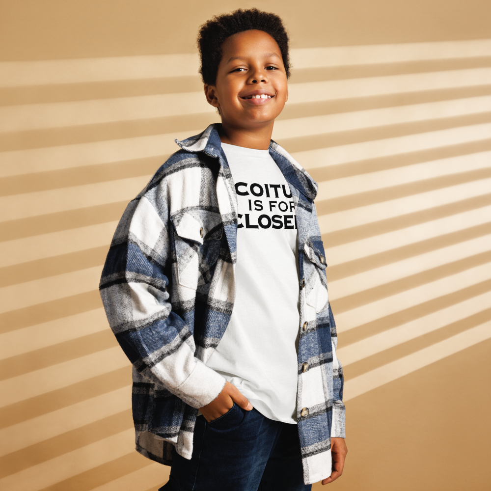 "Coitus Is For Closers" printed on a white youth classic tee worn by a male also wearing a jacket