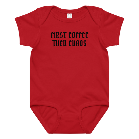 "First Coffee Then Chaos" printed on a red baby jersey bodysuit laying on a flat surface amongst other clothes