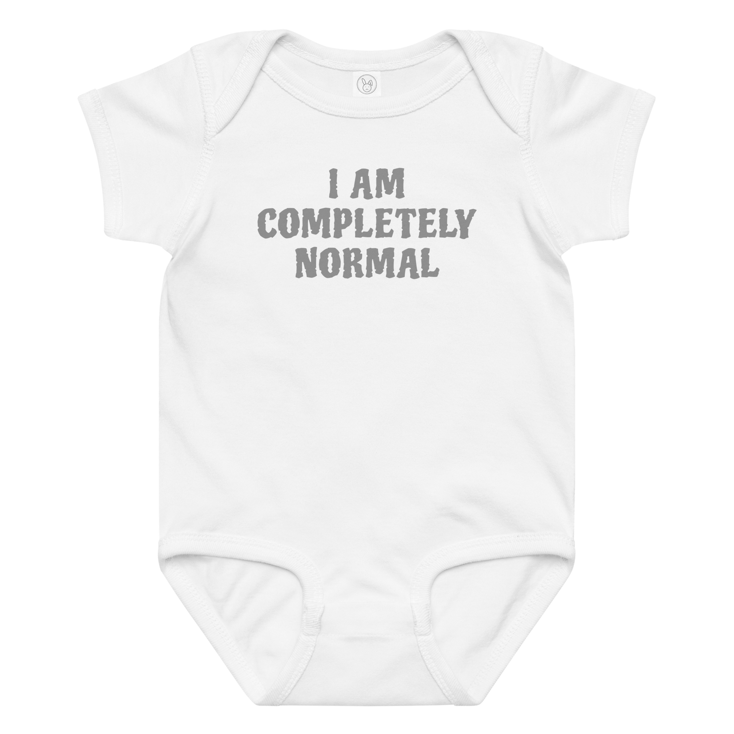 "I am completely normal" printed on a white baby jersey bodysuit laying on a flat surface amongst other clothes