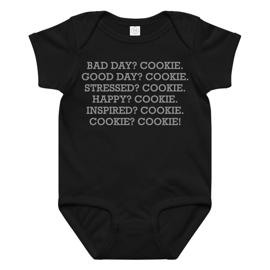 "Bad Day? Cookie. Good Day? Cookie. Stressed? Cookie. Happy? Cookie. Inspired? Cookie. Cookie? Cookie!" printed on a black baby jersey bodysuit laying on a flat surface amongst other clothes