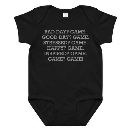 "Bad Day? Game. Good Day? Game. Stressed? Game. Happy? Game. Inspired? Game. Game? Game!" printed on a black baby jersey bodysuit laying on a flat surface amongst other clothes