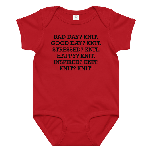 "Bad Day? Knit. Good Day? Knit. Stressed? Knit. Happy? Knit. Inspired? Knit. Knit? Knit!" printed on a red baby jersey bodysuit laying on a flat surface amongst other clothes
