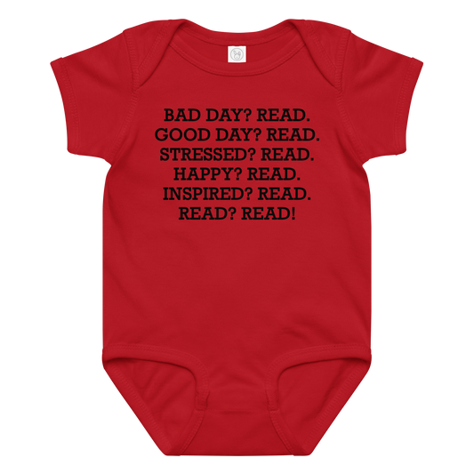 "Bad Day? Read. Good Day? Read. Stressed? Read. Happy? Read. Inspired? Read. Read? Read!" printed on a red baby jersey bodysuit laying on a flat surface amongst other clothes