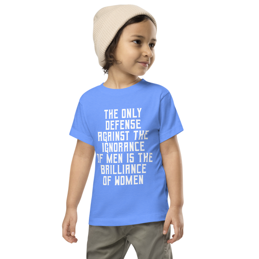 "The Only defense against the ignorance of men is the brilliance of women" printed on a heather columbia blue toddler short sleeve tee worn by a male wearing a cap