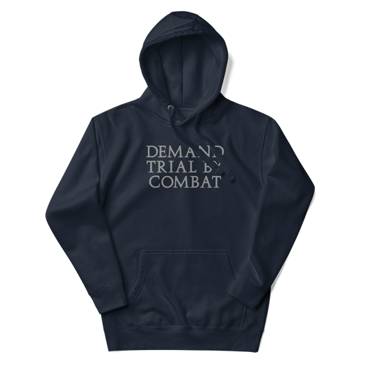 "Demand trial by combat" printed on a navy blazer unisex hoodie laying on a flat surface with the hood up