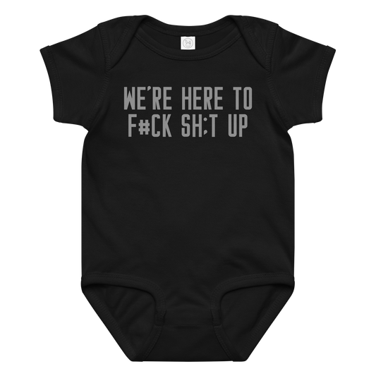 "We're Here To F#Ck Sh:t Up" printed on a black baby jersey bodysuit laying on a flat surface amongst other clothes