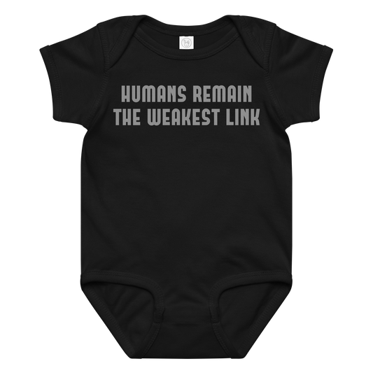 "Humans remain the weakest link" printed on a black baby jersey bodysuit laying on a flat surface amongst other clothes