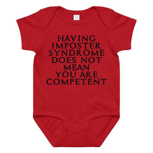 "Having Imposter Syndrome does not mean you are competent" printed on a red baby jersey bodysuit laying on a flat surface amongst other clothes