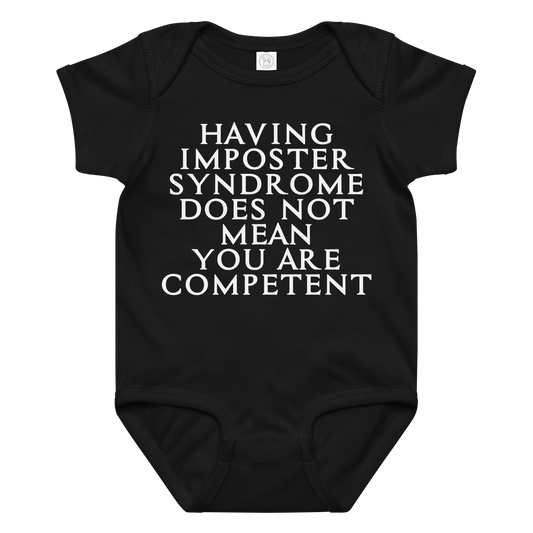 "Having Imposter Syndrome does not mean you are competent" printed on a black baby jersey bodysuit laying on a flat surface amongst other clothes