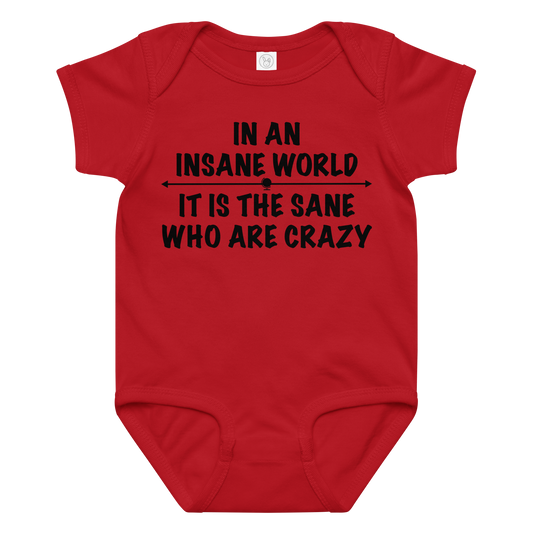 "In an insane world, it is the sane who are crazy" printed on a red baby jersey bodysuit laying on a flat surface amongst other clothes