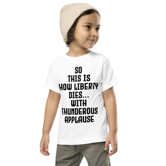 "So this is how liberty dies… with thunderous applause" printed on a white toddler short sleeve tee worn by a male wearing a cap