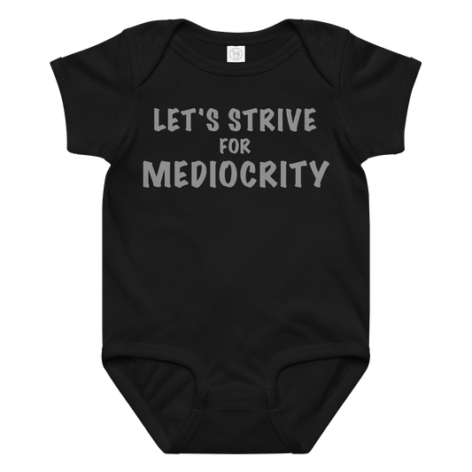 "Let's strive for mediocity" printed on a black baby jersey bodysuit laying on a flat surface amongst other clothes