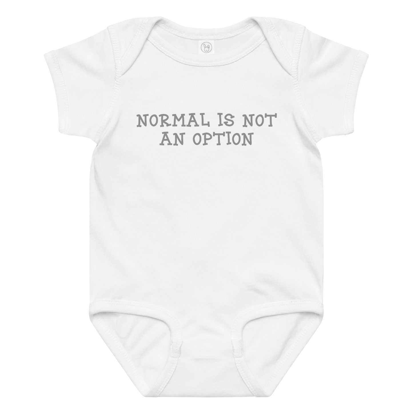 "Normal is not an option" printed on a white baby jersey bodysuit laying on a flat surface amongst other clothes