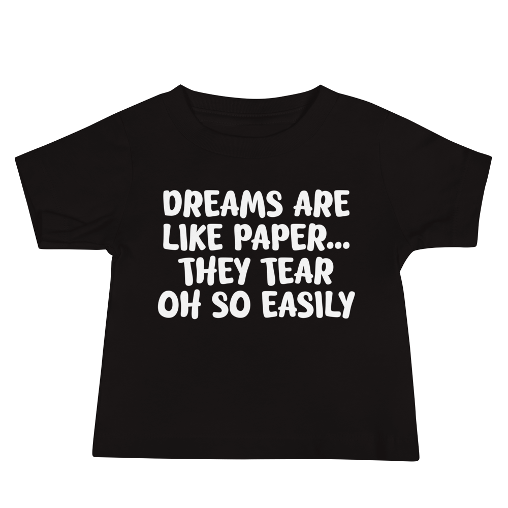"Dreams are like paper, they tear oh so easily" printed on a black baby jersey short sleeve tee laying on a flat surface