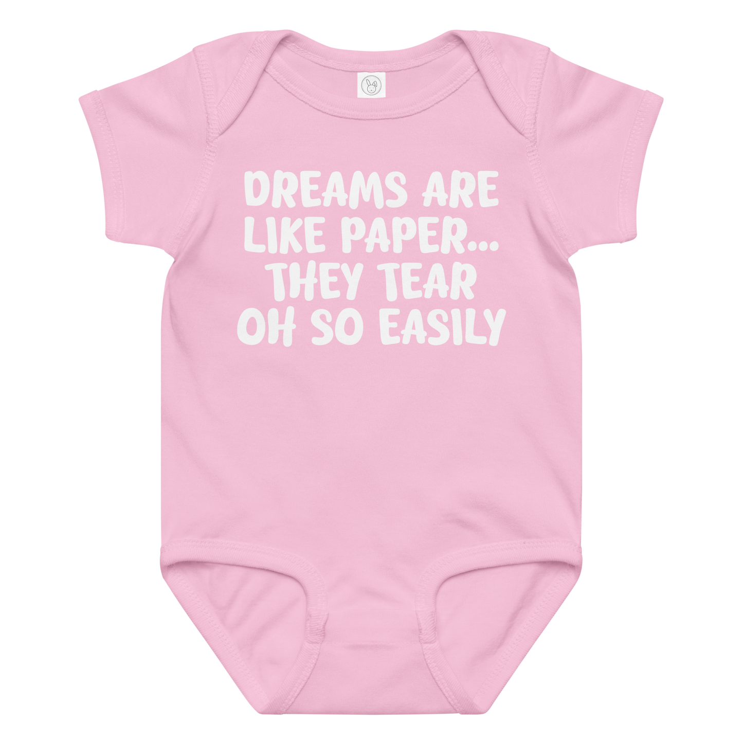 "Dreams are like paper, they tear oh so easily" printed on a pink baby jersey bodysuit laying on a flat surface amongst other clothes
