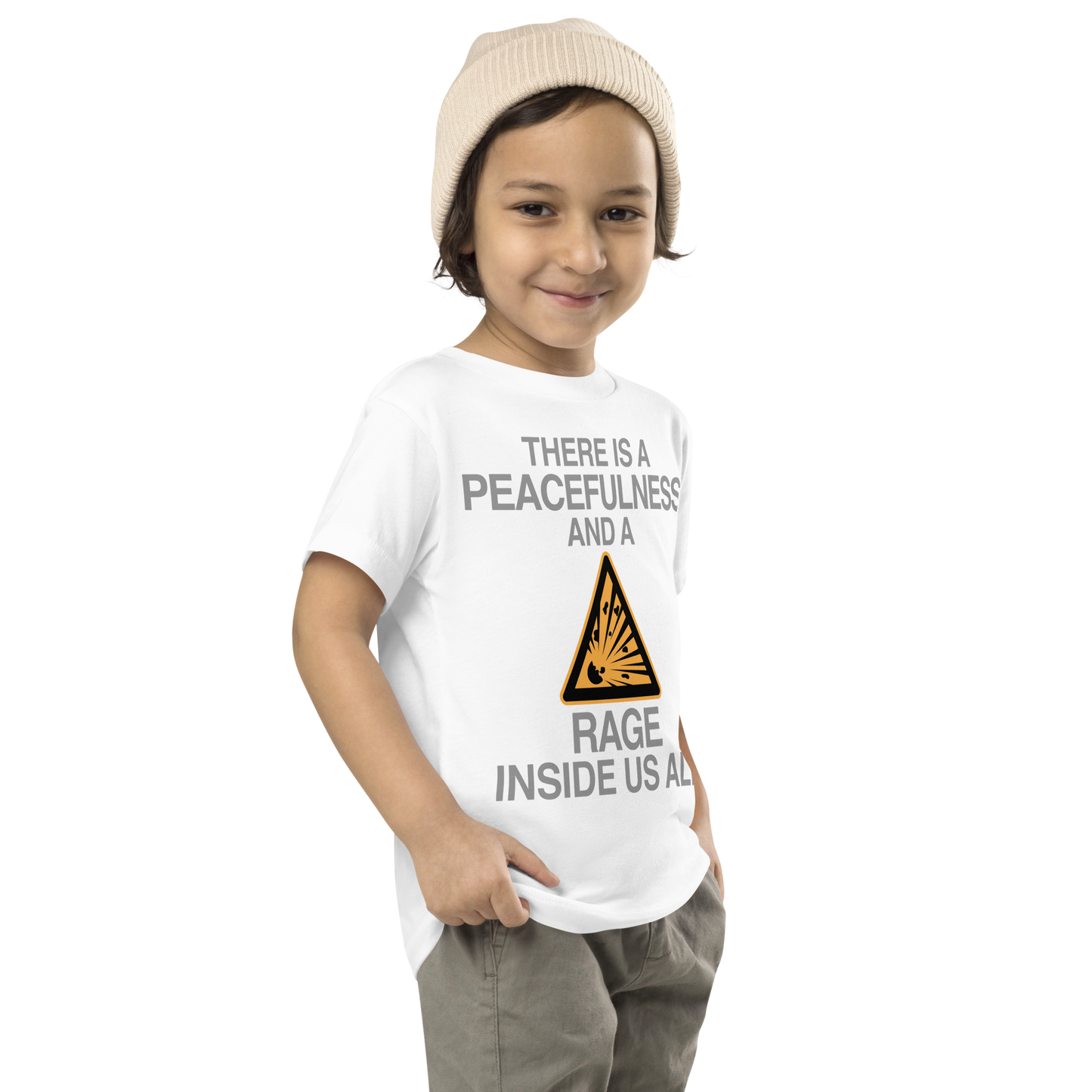 "There is a peacefulness and a rage inside us all" printed on a white toddler short sleeve tee worn by a male who is also wearing a knit cap