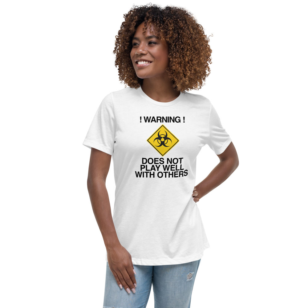 "!Warning! Does Not Play Well With Others" printed on a white women's relaxed t-shirt worn by a female