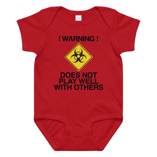 "!Warning! Does Not Play Well With Others" printed on a red baby jersey bodysuit laying on a flat surface amongst other clothes
