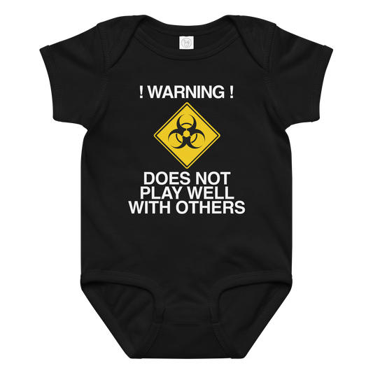"!Warning! Does Not Play Well With Others" printed on a black baby jersey bodysuit laying on a flat surface amongst other clothes