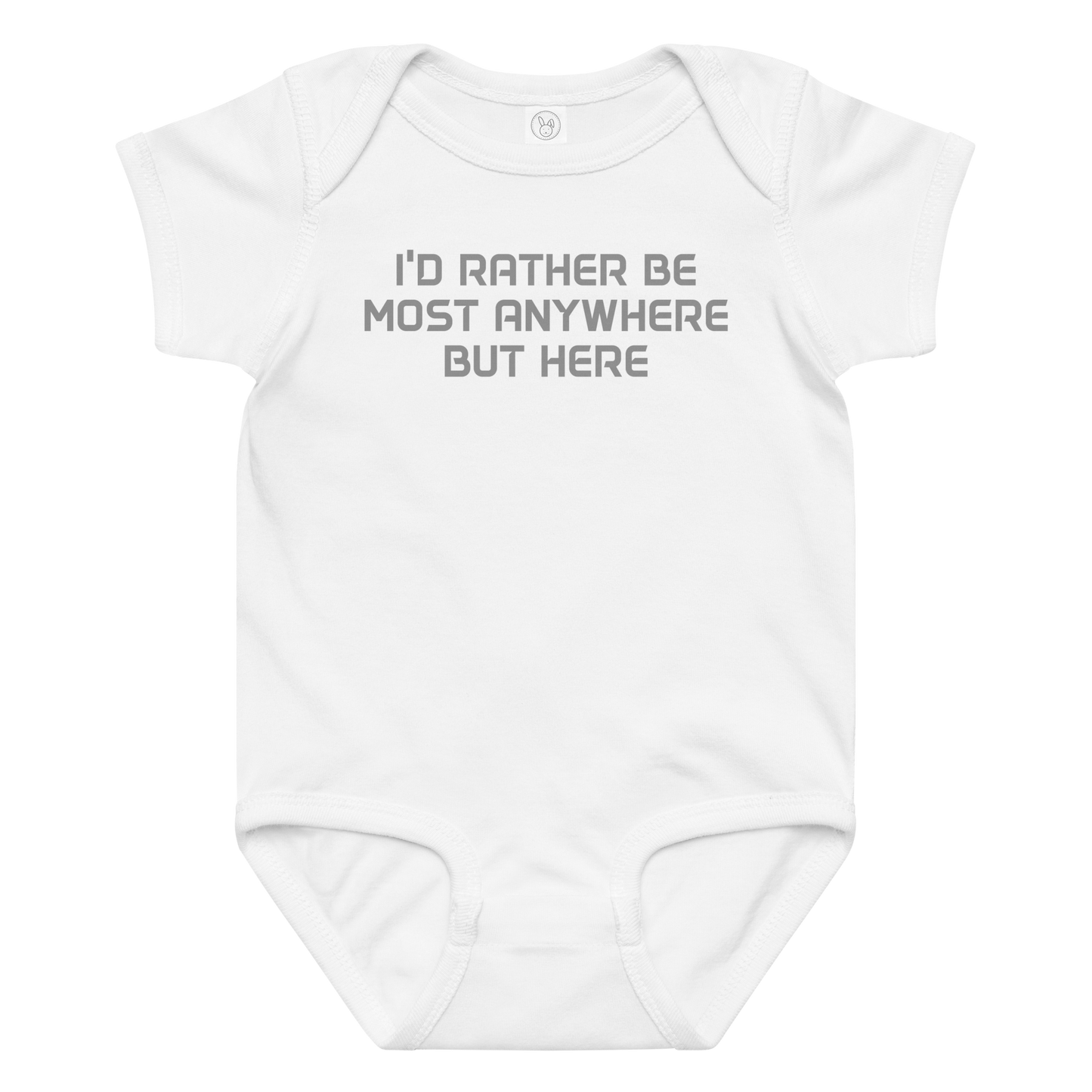 "I’d rather be most anywhere but here" printed on a white baby jersey bodysuit laying on a flat surface amongst other clothes