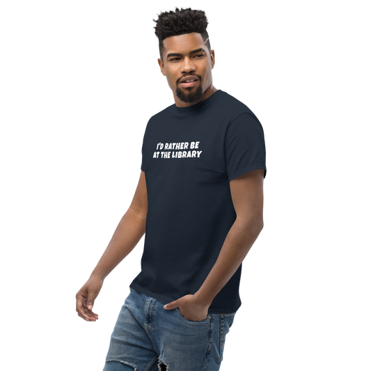 "I’d rather be at the library" printed on a navy unisex classic tee worn by a male