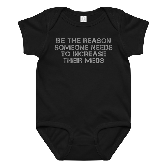 "Be the reason someone needs to increase their meds" printed on a black baby jersey bodysuit laying on a flat surface amongst other clothes
