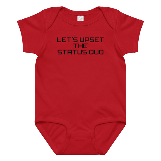 "Let's upset the status quo!" printed on a red baby jersey bodysuit laying on a flat surface amongst other clothes