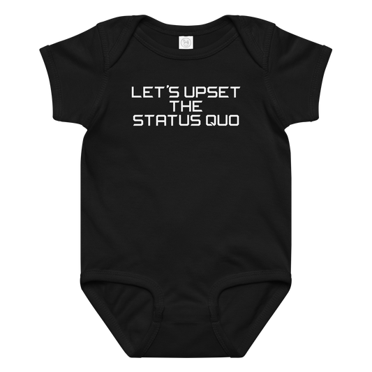 "Let's upset the status quo!" printed on a black baby jersey bodysuit laying on a flat surface amongst other clothes