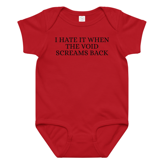 "I hate it when the void screams back" printed on a red baby jersey bodysuit laying on a flat surface amongst other clothes