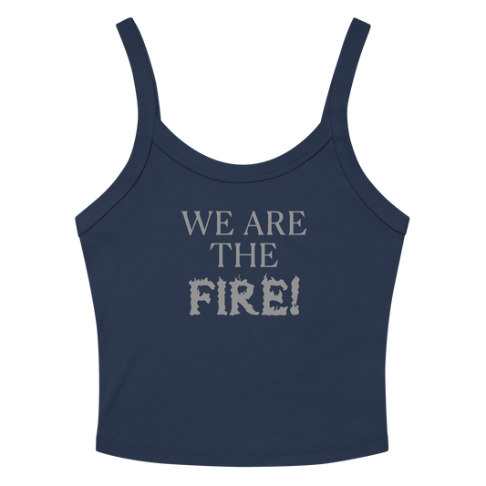"We are the fire!" printed on a solid navy blend women's micro-rib tanktop laying on a flat surface amongst sunglasses and shorts