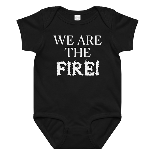 "We are the fire!" printed on a black baby jersey bodysuit laying on a flat surface amongst other clothes
