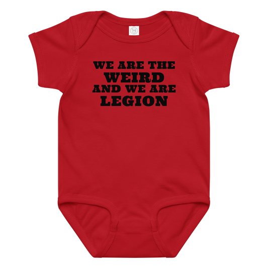 "We are the weird and we are legion" printed on a red baby jersey bodysuit laying on a flat surface amongst other clothes