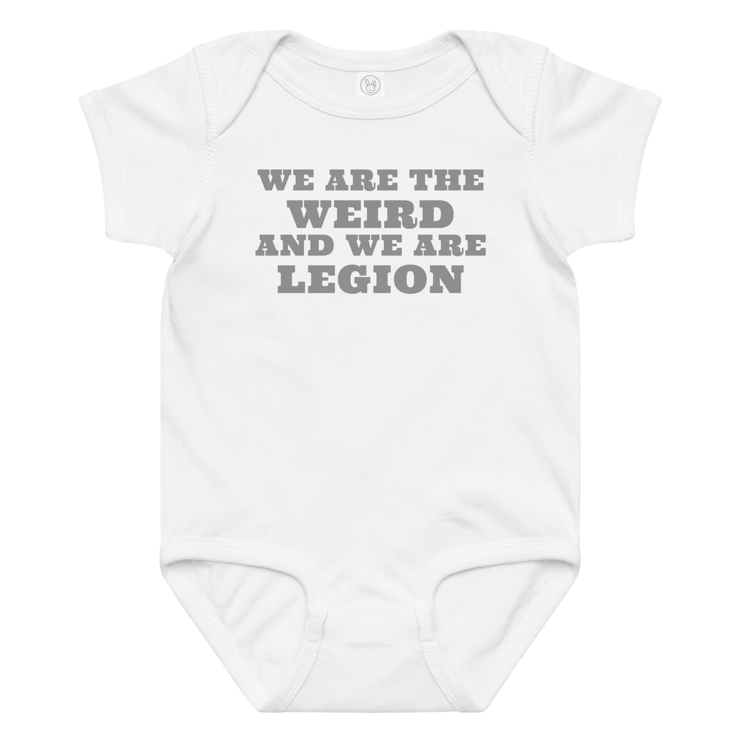 "We are the weird and we are legion" printed on a white baby jersey bodysuit laying on a flat surface amongst other clothes