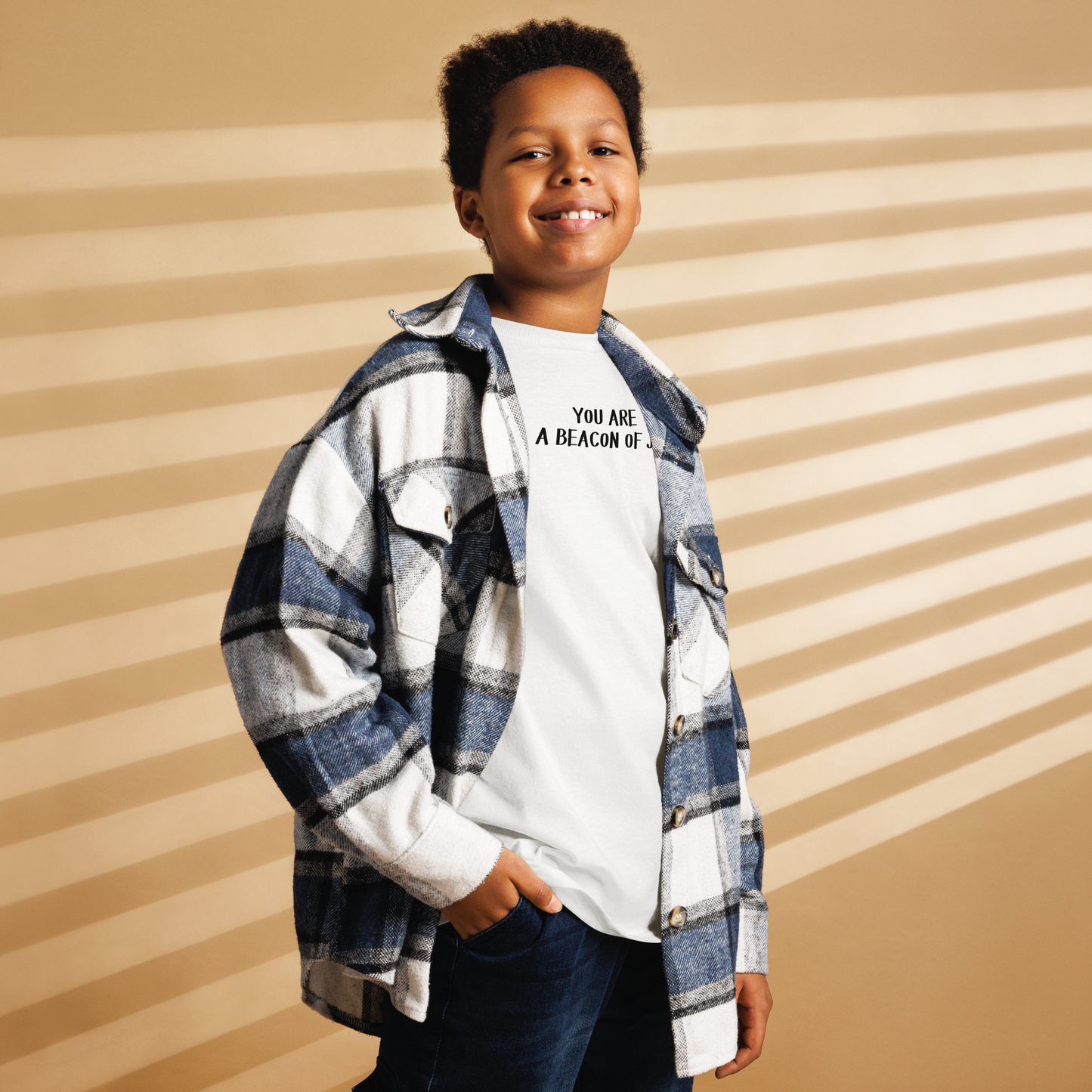 "You are a beacon of joy" printed on a white youth classic tee worn by a male also wearing a jacket