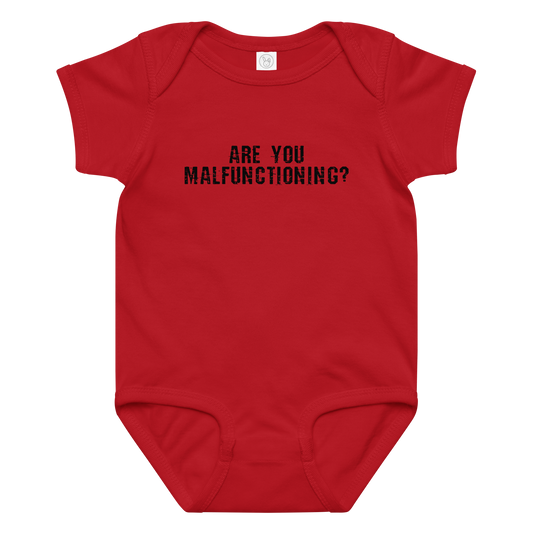"Are you malfunctioning?" printed on a red baby jersey bodysuit laying on a flat surface amongst other clothes