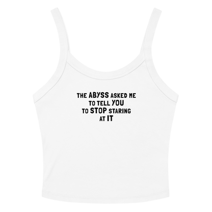 "The Abyss asked me to tell you to stop staring at it" printed on a solid white blend women's micro-rib tanktop laying on a flat surface amongst sunglasses and shorts